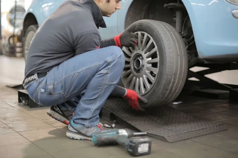 Mecánico ajustando la llanta de un auto